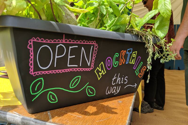 A plant pot with the words open and mocktails written on it in chalk pens
